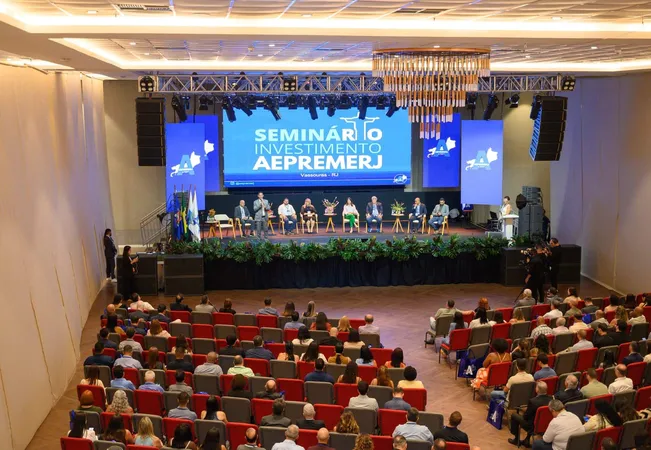 Plenária lotada do Seminário de Investimentos AEPREMERJ, em Vassouras (RJ), com a mesa de debate no palco.